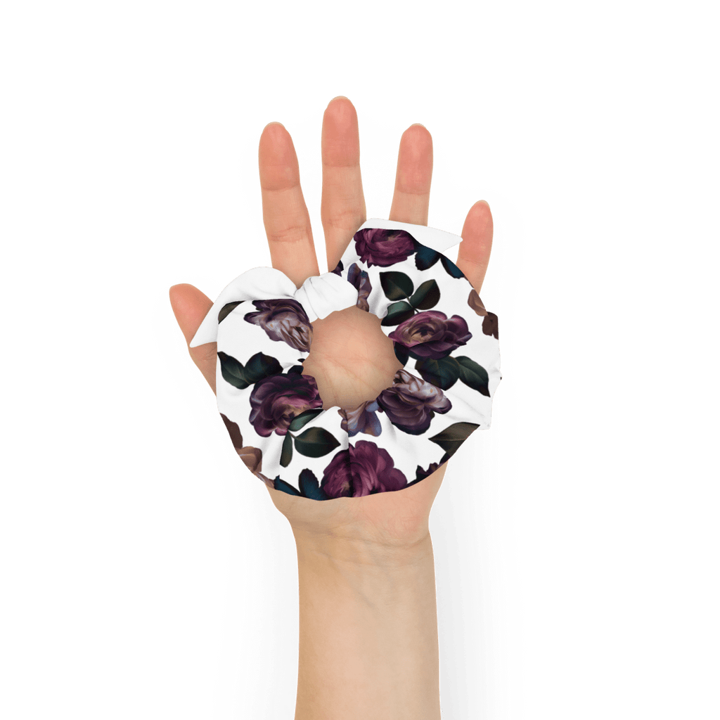 Dark purple roses with dark green leaves on a white background. Held in a woman's palm for size.