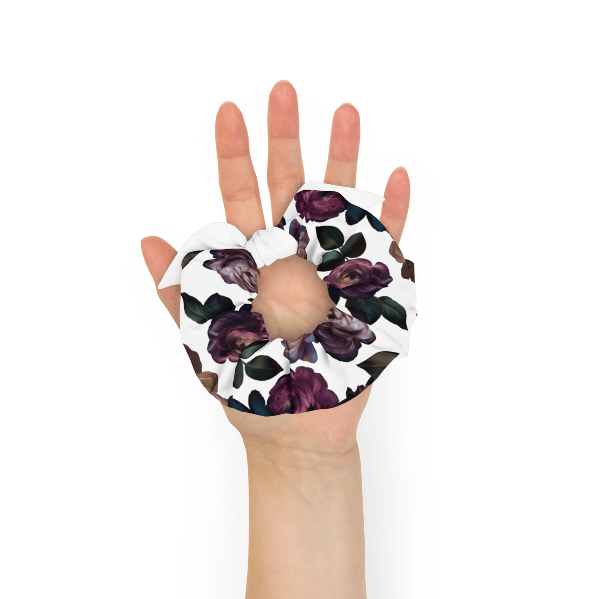 Dark purple roses with dark green leaves on a white background. Held in a woman's palm for size.